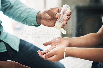 Buy stock photo Shot of two unrecognizable people using hand sanitiser at home