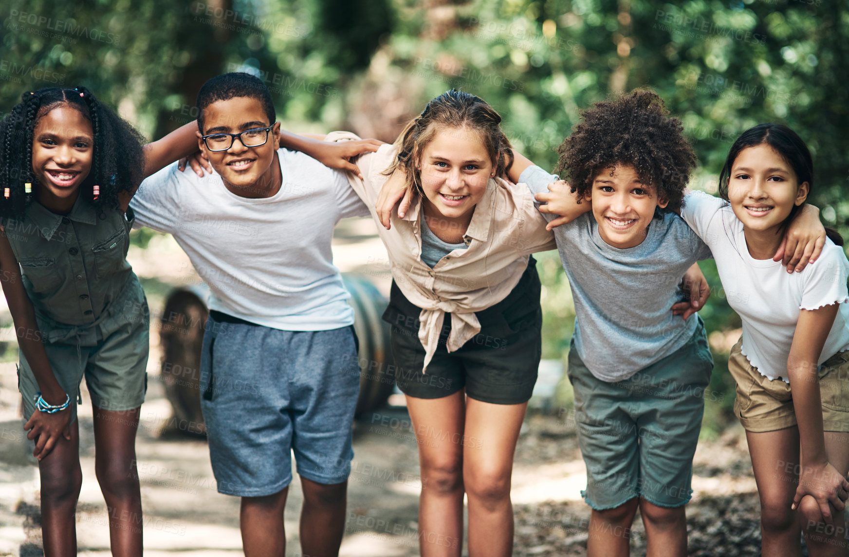 Buy stock photo Shot of a group of teenagers embracing in nature at summer camp