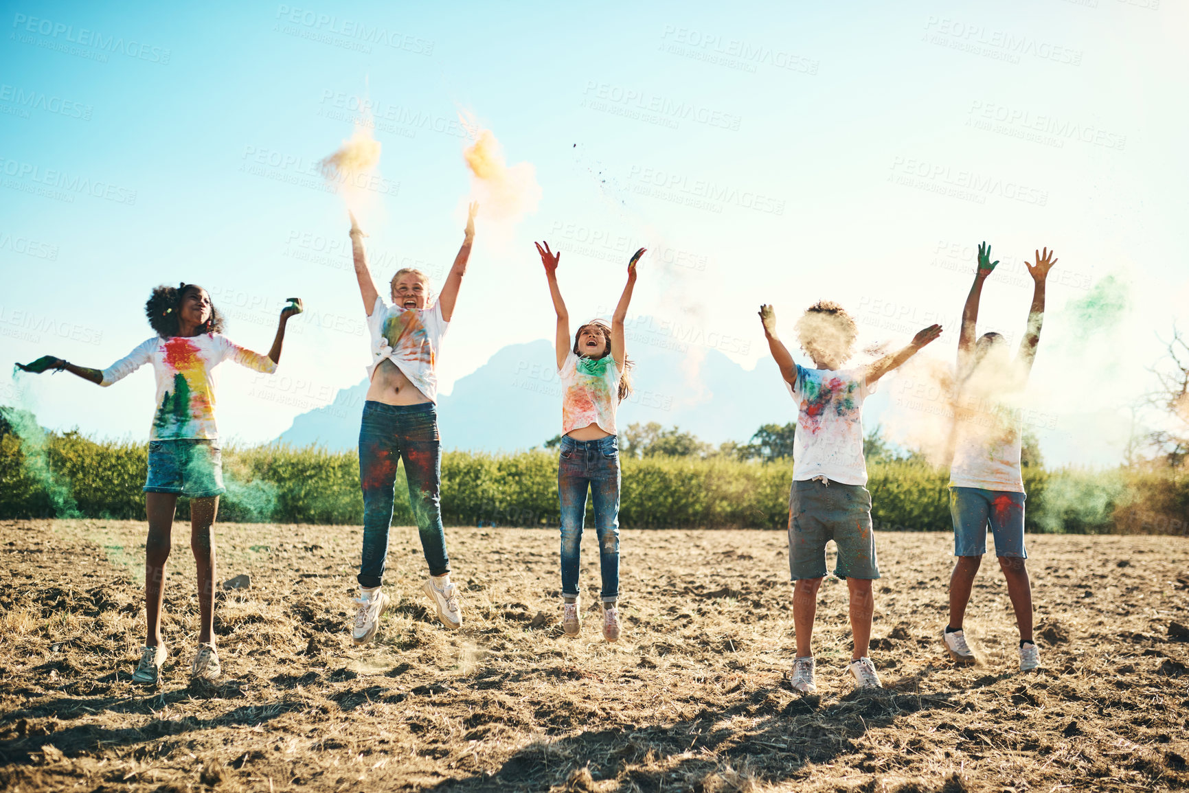 Buy stock photo Shot of a group of teenagers having fun with colourful powder at summer camp