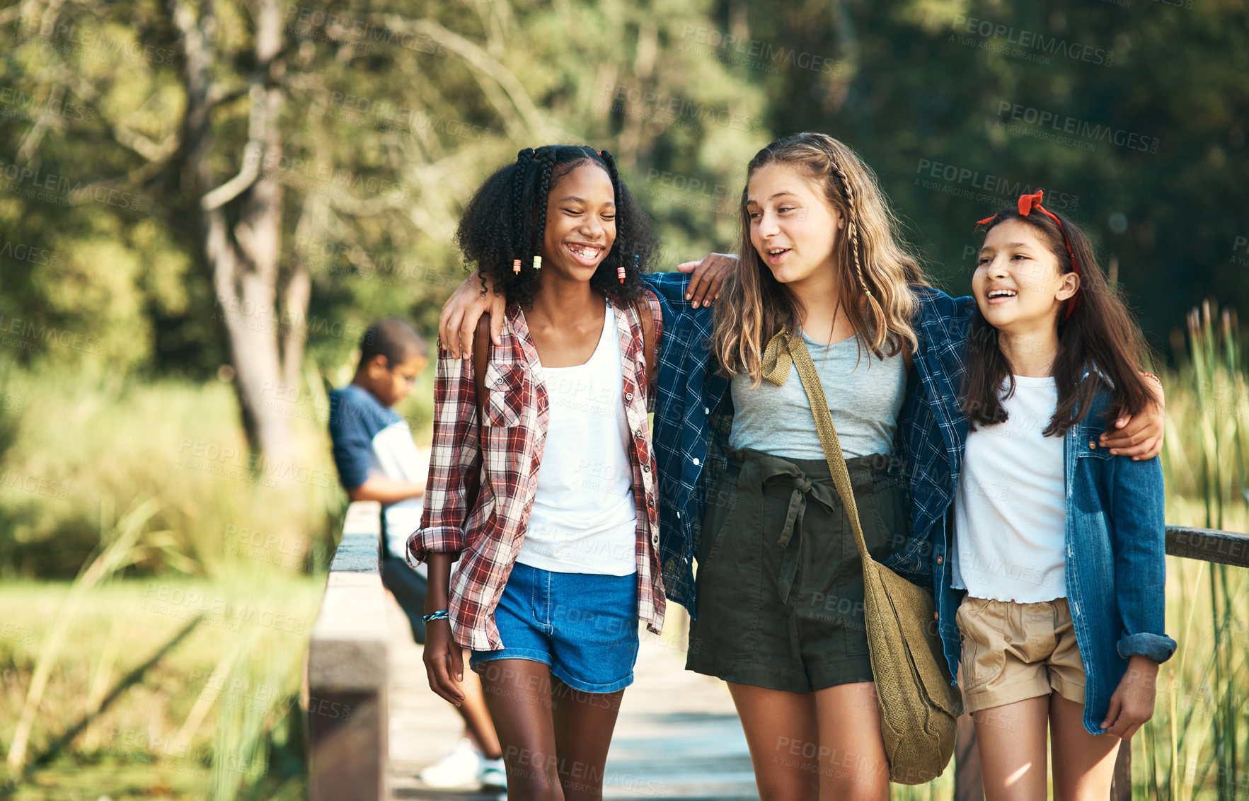 Buy stock photo Shot of a group of teenage girls walking and chatting in nature at summer camp