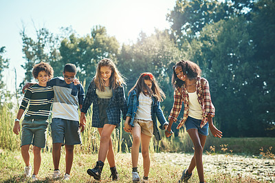 Buy stock photo Shot of a group of teenagers walking through nature together at summer camp