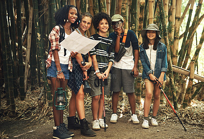 Buy stock photo Shot of a group of teenagers looking at a map while exploring nature together at summer camp