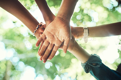 Buy stock photo Shot of a group of  unrecognisable teenagers standing in a circle and joining their hands in solidarity at summer camp