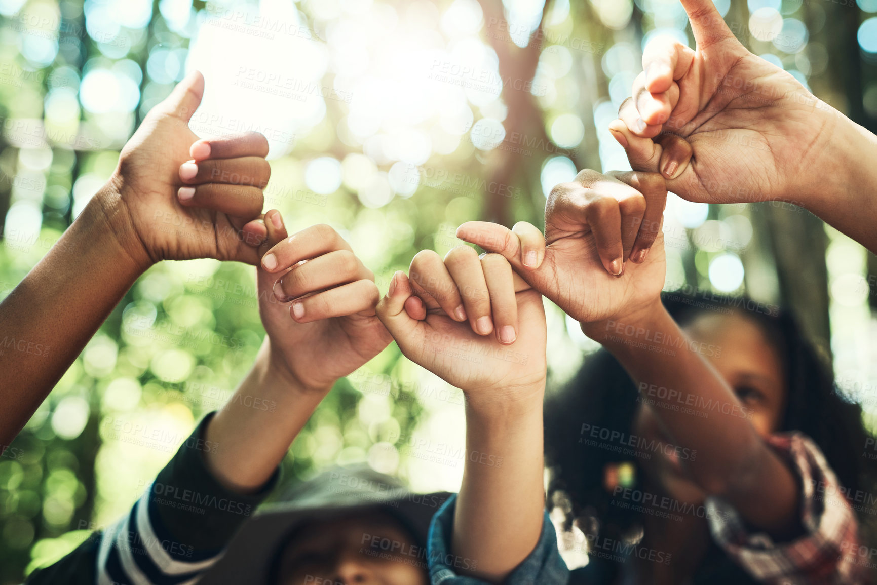 Buy stock photo Shot of a group of teenagers linking fingers at summer camp