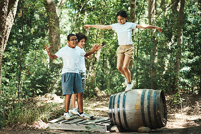 Buy stock photo Shot of a group of teenagers having fun with a barrel in nature at summer camp