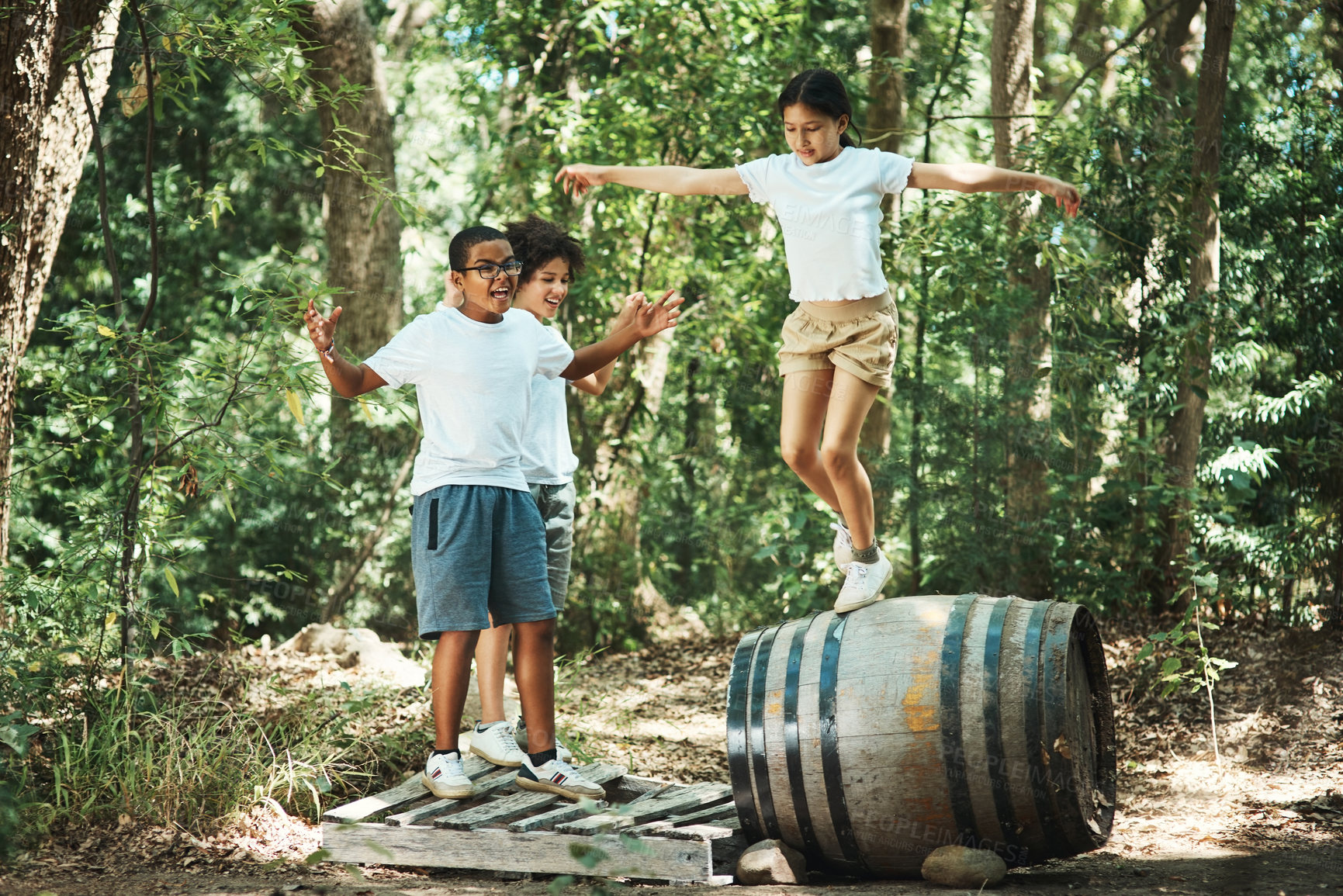 Buy stock photo Shot of a group of teenagers having fun with a barrel in nature at summer camp