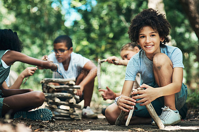 Buy stock photo Shot of a group of teenagers building a pile of wood at summer camp