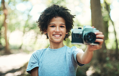 Buy stock photo Shot of a teenage boy using a camera while hiking through the forest at summer camp