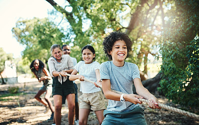 Buy stock photo Shot of a group of teenagers playing a game of tug of war at summer camp