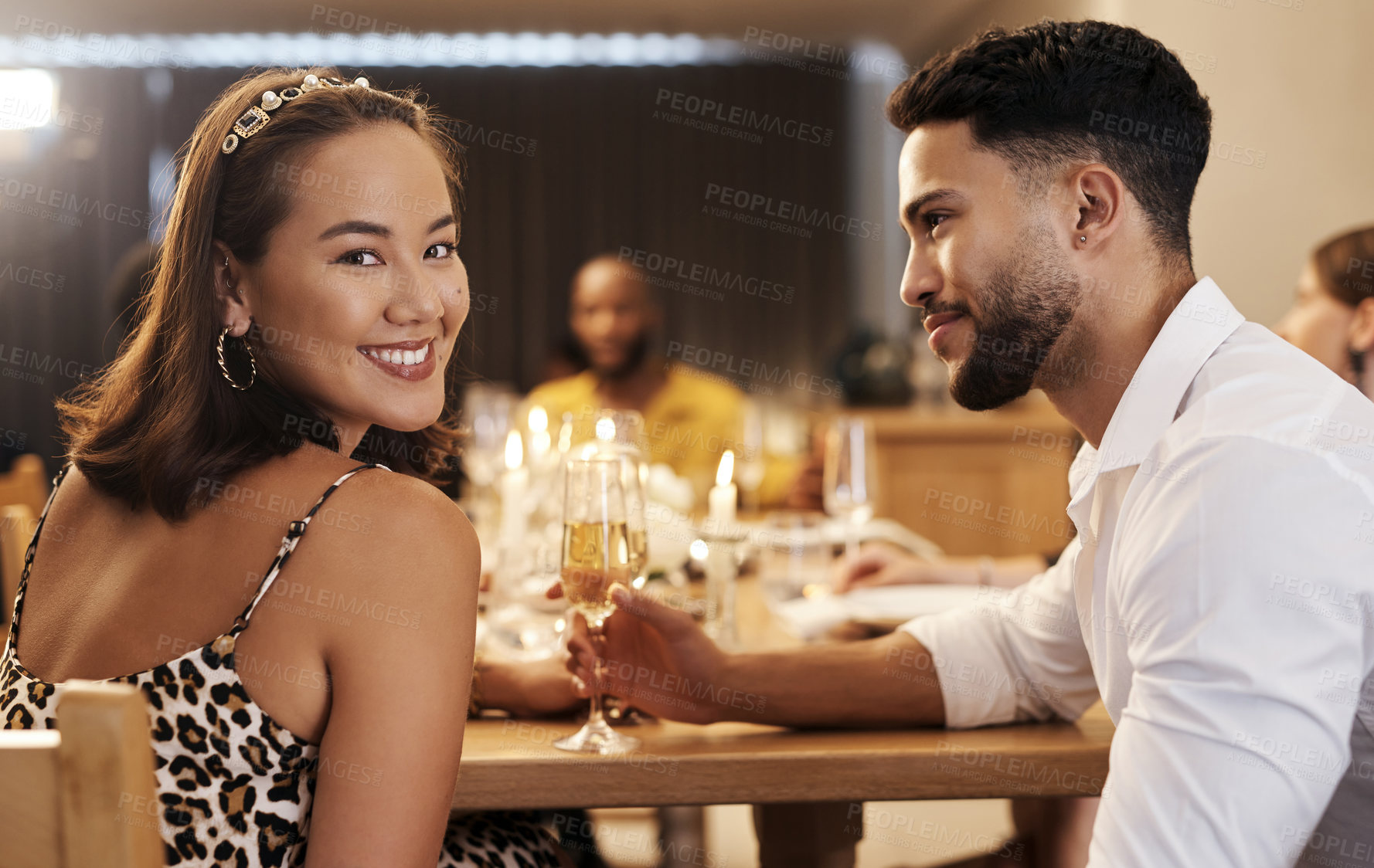 Buy stock photo Shot of an attractive young woman sitting with her boyfriend during a New Year's dinner party