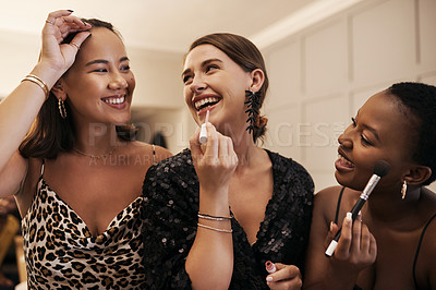 Buy stock photo Shot of a diverse group of friends standing together and doing their makeup during a New Year's dinner party
