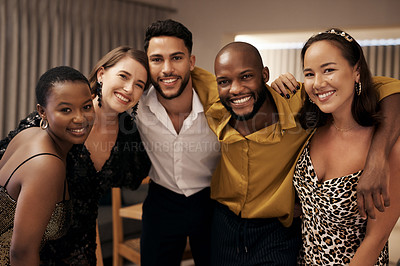 Buy stock photo Shot of a diverse group of friends standing with their arms around each other during a New Year's dinner party