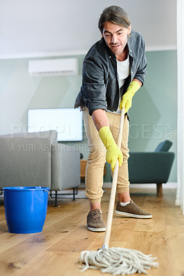 Buy stock photo Shot of a young man mopping the floor at home