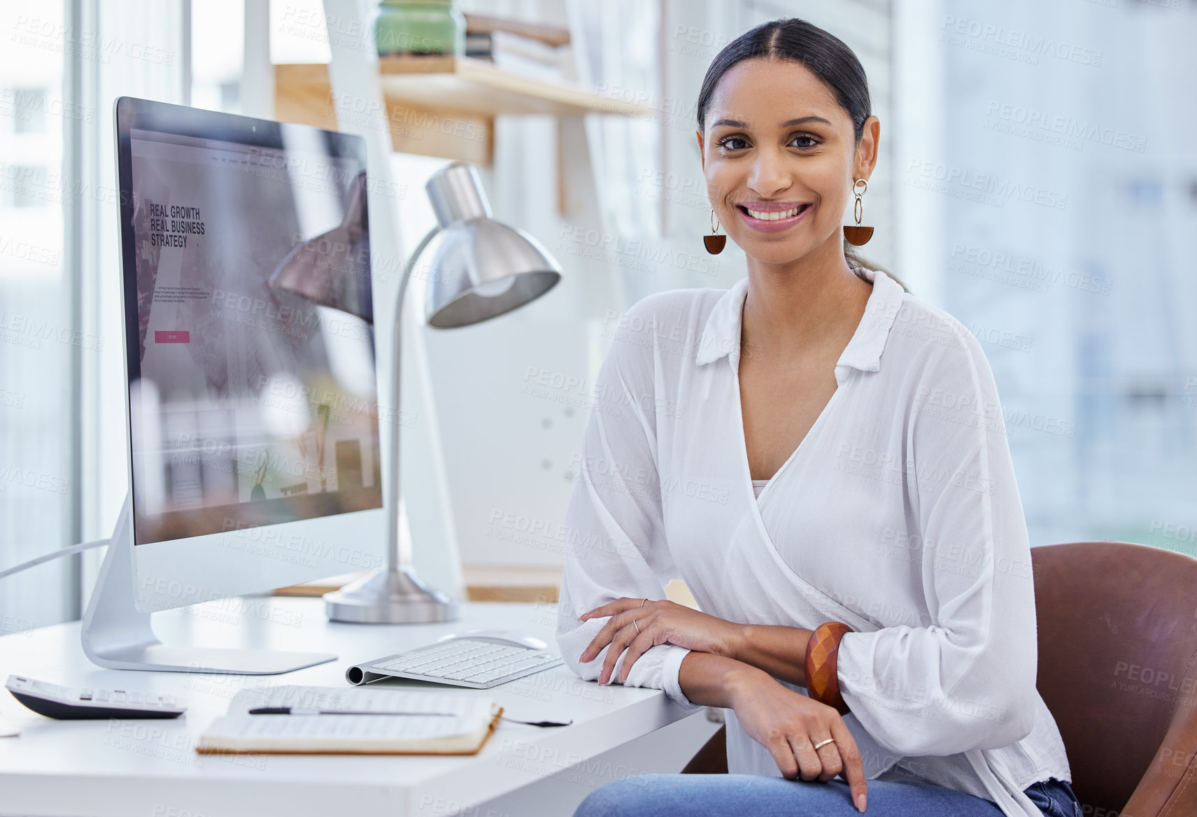 Buy stock photo Portrait of a young businesswoman sitting at a desk in a modern office