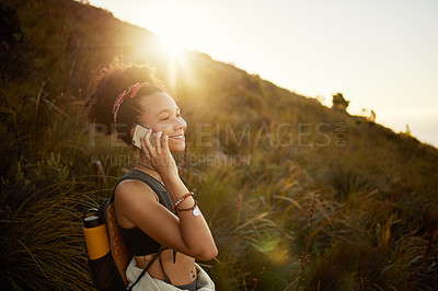 Buy stock photo Shot of a young woman talking on her cellphone while out hiking