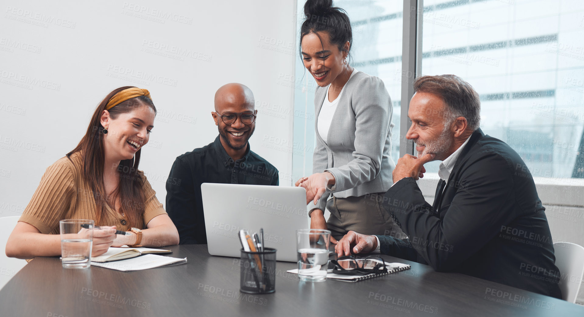 Buy stock photo Shot of a group of businesspeople working together on a laptop in an office