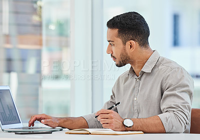 Buy stock photo Laptop, serious and business man writing notes for research, analytics or reading data in office. Computer, graphs and professional on notebook statistics, info or financial advisor work on project