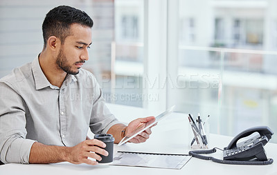 Buy stock photo Shot of a young businessman using a digital tablet at work