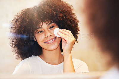 Buy stock photo Shot of a beautiful young woman using a cotton pad to clean her face