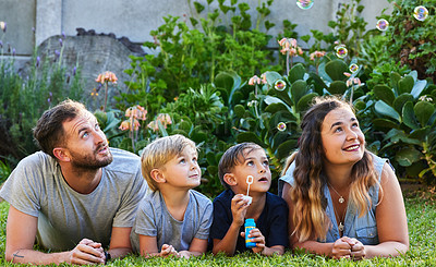 Buy stock photo Family, kids and love with bubbles in garden for happy relationship, learning and bonding time. Parents, children and smile in backyard for relax together with development, safe and soap toy on grass