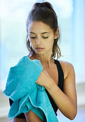 Buy stock photo Shot of a woman drying herself with a towel after her workout