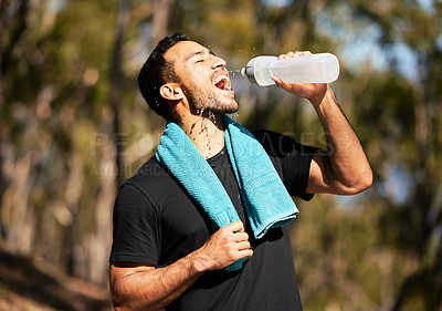 Buy stock photo Shot of a man drinking water while out of a run