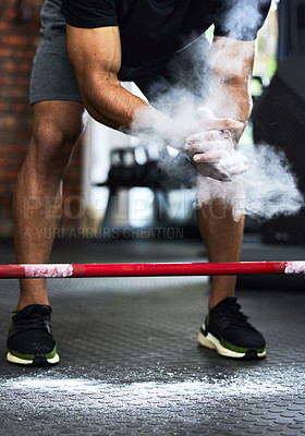 Buy stock photo Cropped shot of a man dusting his hands with chalk powder at the gym