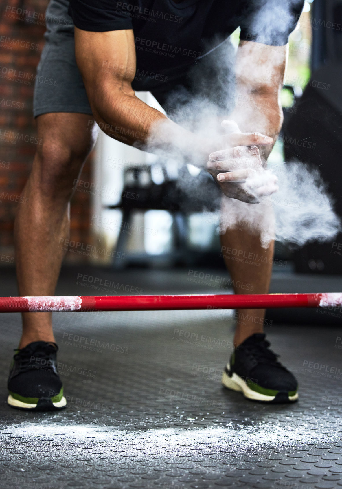 Buy stock photo Cropped shot of a man dusting his hands with chalk powder at the gym