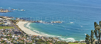 Buy stock photo Landscape view of a beautiful coastal city near the beach on a summer day. Aerial view of a peaceful urban town with a relaxing view of the ocean. Top view of private or holiday houses by the sea