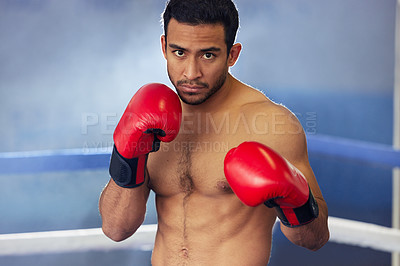 Buy stock photo Cropped portrait of a handsome young male boxer standing with his guard up during a fight in the ring