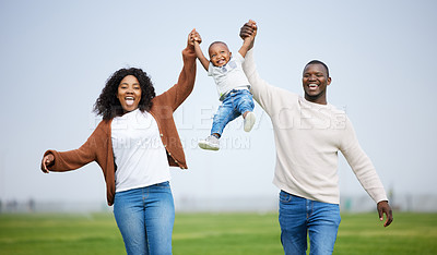 Buy stock photo Shot of a young couple playing with their son in a park