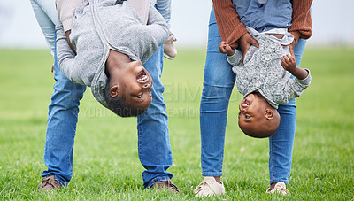 Buy stock photo Shot of two children hanging upside down by their parents outside