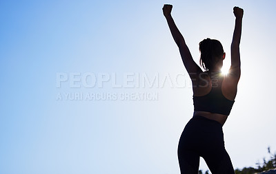 Buy stock photo Rearview shot of a sporty young woman standing with her arms outstretched while exercising outdoors