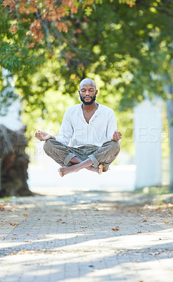 Buy stock photo Full length shot of a handsome young man levitating while meditating outside at the park