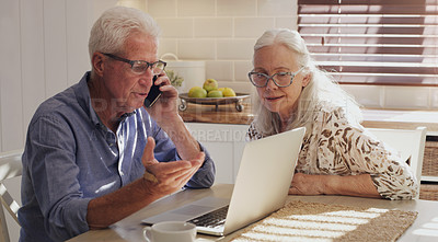 Buy stock photo Shot of a senior couple sitting together in their kitchen at home and calculating their finances