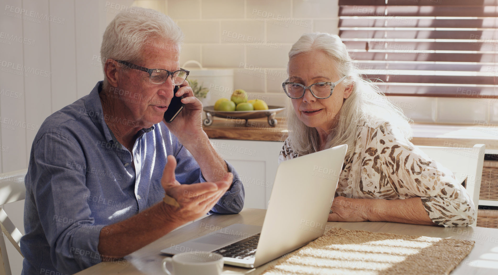 Buy stock photo Shot of a senior couple sitting together in their kitchen at home and calculating their finances