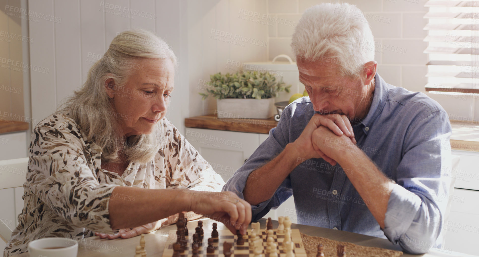 Buy stock photo Senior, retired and couple at home with chess on board game by bonding, thinking and strategy for decision. Elderly,  man and woman in kitchen with love, relax and trust for challenge of skills
