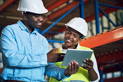 Buy stock photo Shot of two builders using a digital tablet while working at a construction site
