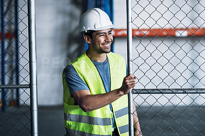 Buy stock photo Shot of a young builder opening the gates to a construction site