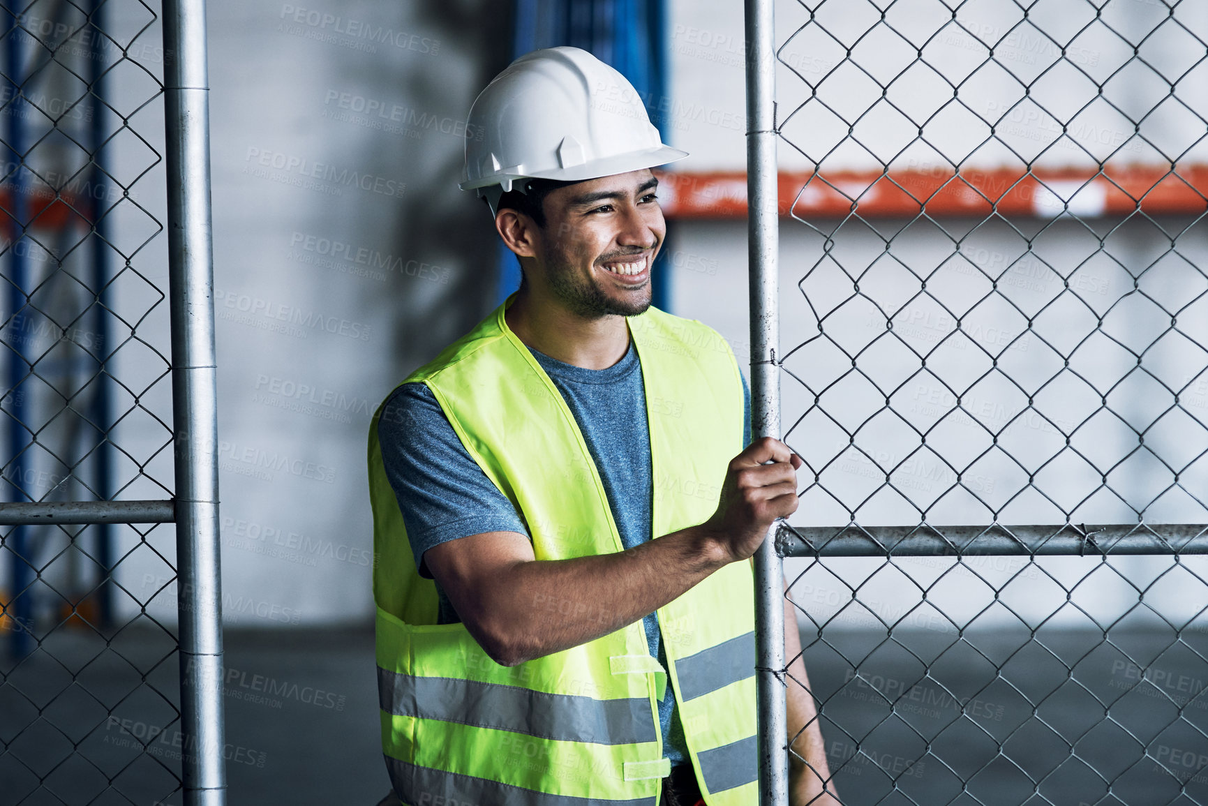 Buy stock photo Shot of a young builder opening the gates to a construction site