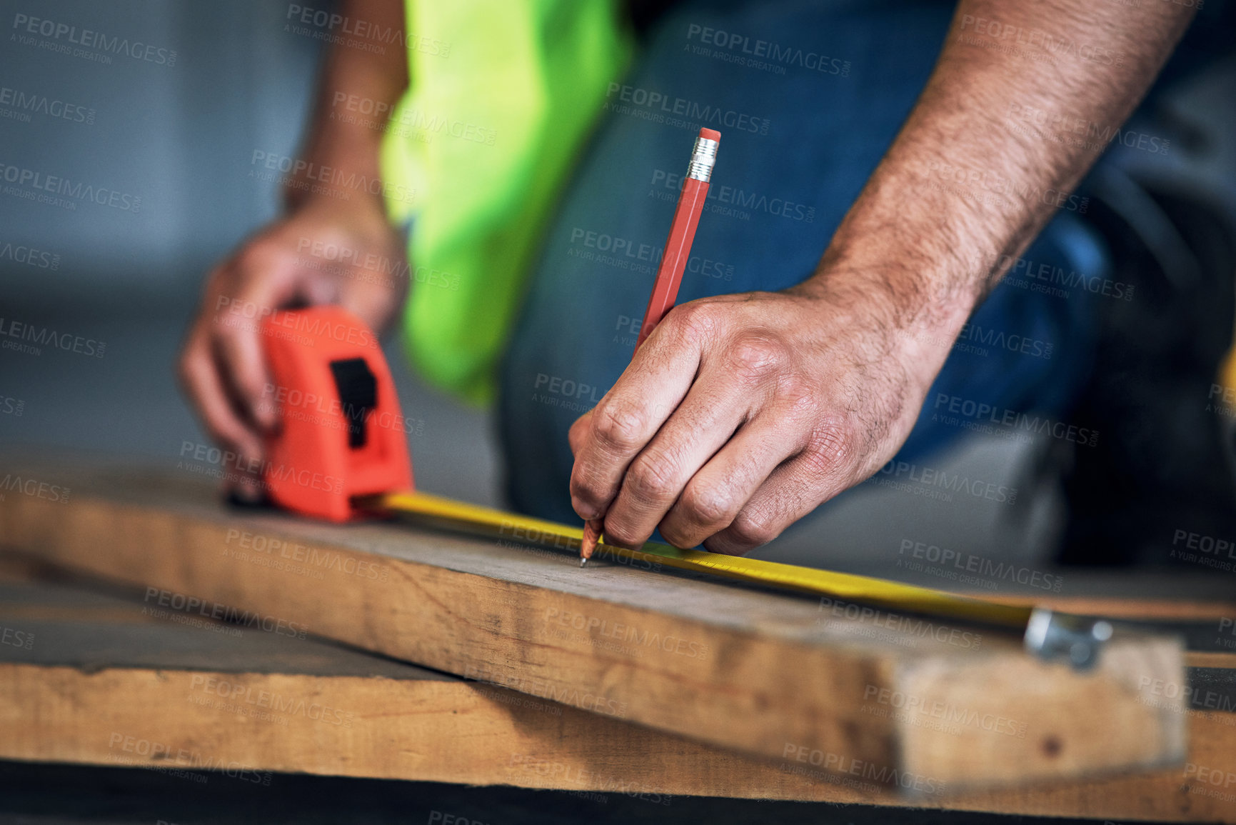 Buy stock photo Shot of a young builder using a measuring tape at a construction site