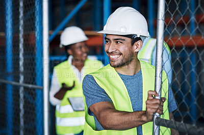 Buy stock photo Shot of a young builder opening the gates to a construction site