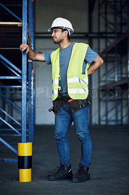 Buy stock photo Shot of a young man experiencing back pain while working at a construction site