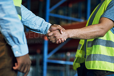 Buy stock photo Shot of two builders shaking hands at a construction site