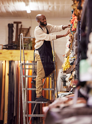 Buy stock photo Shot of a young man working at his job in a shop