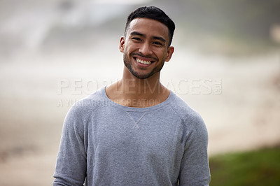 Buy stock photo Shot of a happy young man standing outside