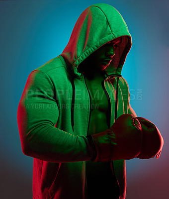 Buy stock photo Studio shot of a sporty young man wearing boxing gloves