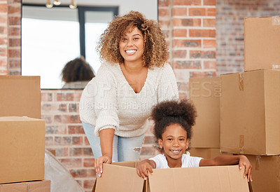Buy stock photo shot of a mother pushing her daughter in a box at home