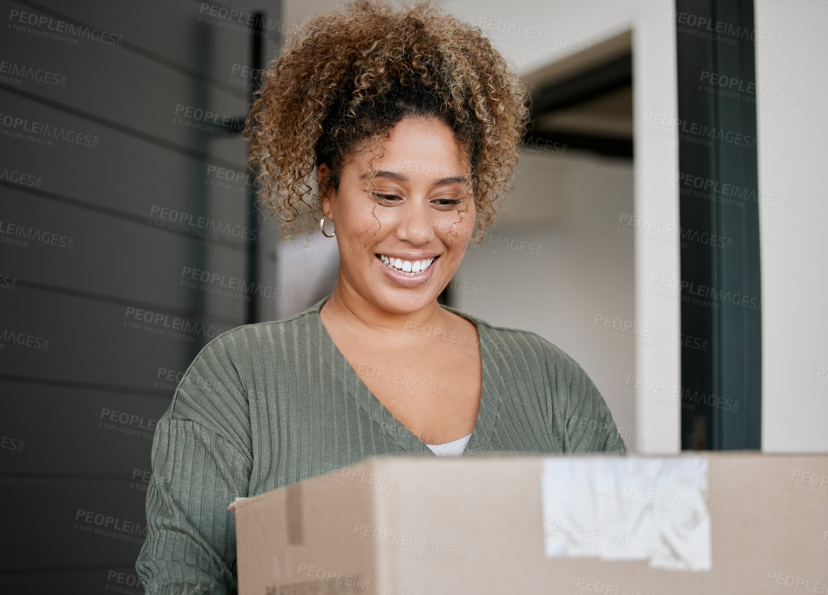 Buy stock photo Shot of a young woman carrying a box at home
