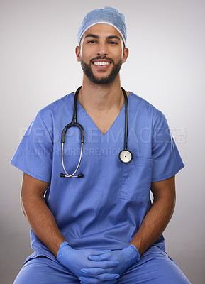 Buy stock photo Shot of a handsome young nurse sitting alone in the studio
